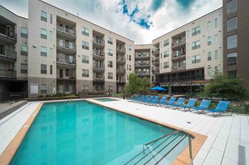 A large swimming pool in front of apartment buildings.